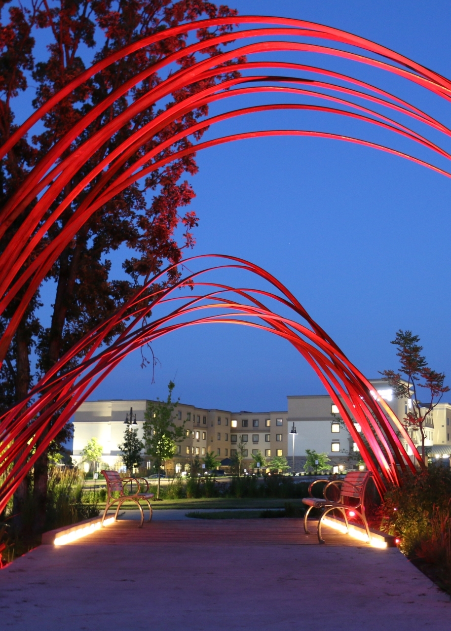 Red light arches over walkway at night